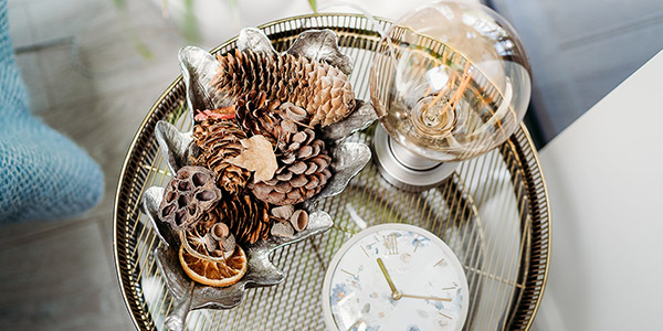 Self-compassion break - Clock on table with lamp and pine cones