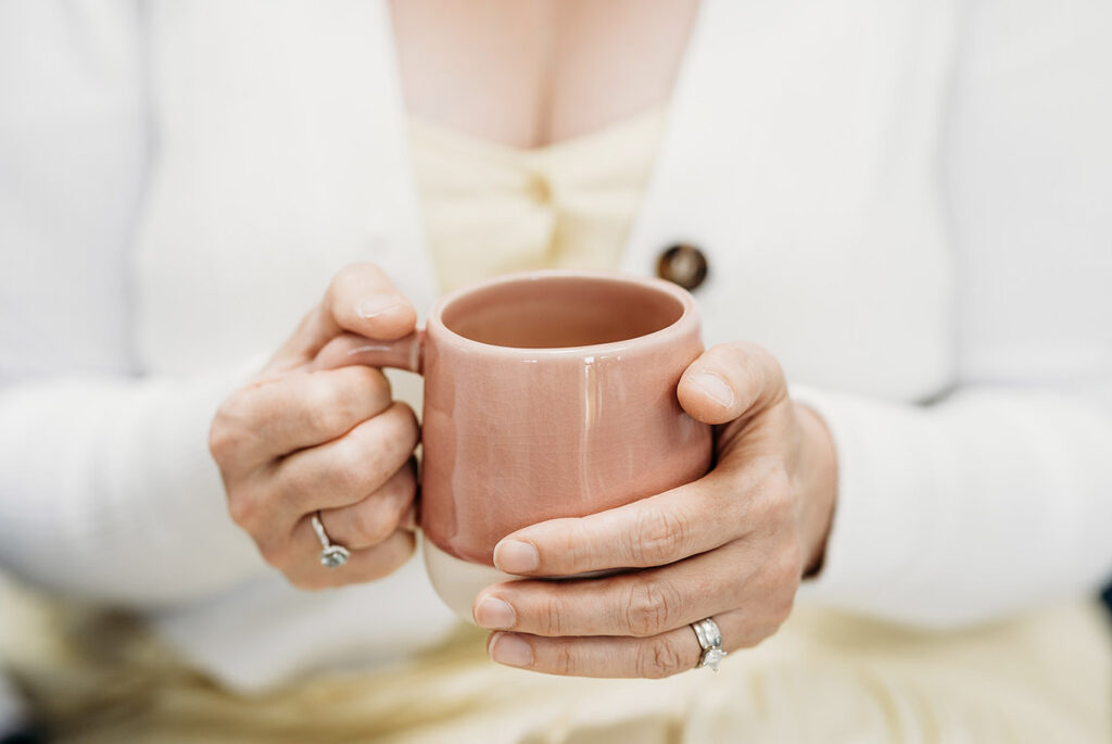 Coaching through cancer and beyond - Hands holding mug